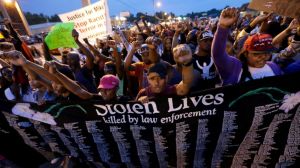 People protest the police shooting death of Michael Brown a week ago in Ferguson, Mo., Saturday, Aug. 16, 2014. | Image Courtesy of abcnews.go.com